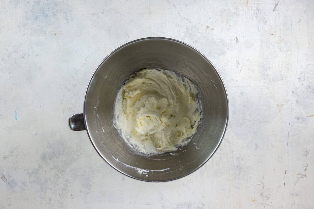 Stainless steel mixing bowl with cream cheese, sugar, lemon juice, and 1 cup Cool Whip all mixed up.