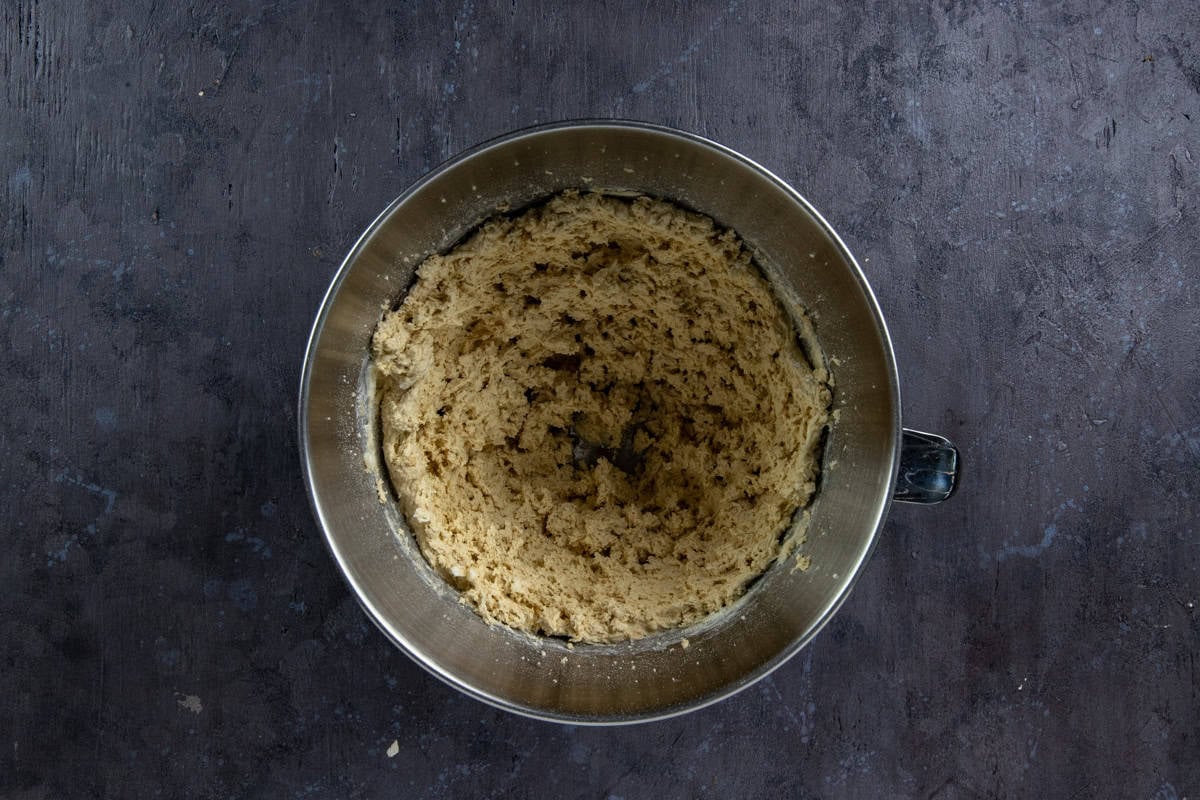 Butter, brown sugar, and white sugar blended in a stainless steel mixing bowl.