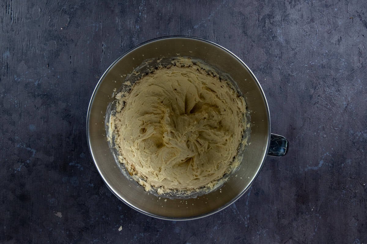 Butter, brown sugar, and white sugar blended in a stainless steel mixing bowl.