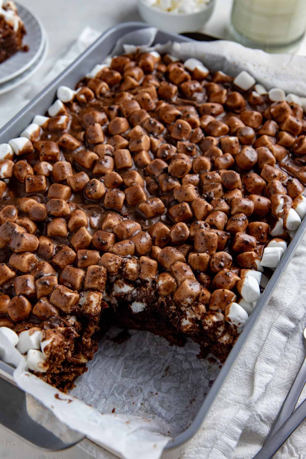 A 9x13-inch cake pan of Mississippi Mud Sheet Cake with one square slice removed.