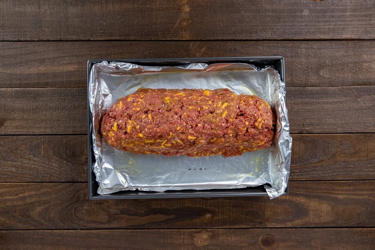 The uncooked meatloaf on a sheetpan lined with foil.