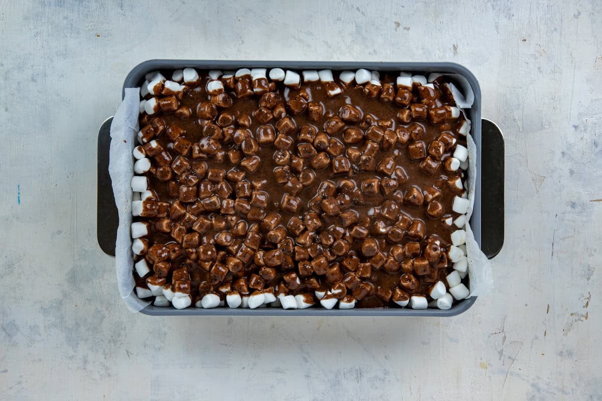 Chocolate icing poured over the hot, marshmallow-topped cake in the cake apn.