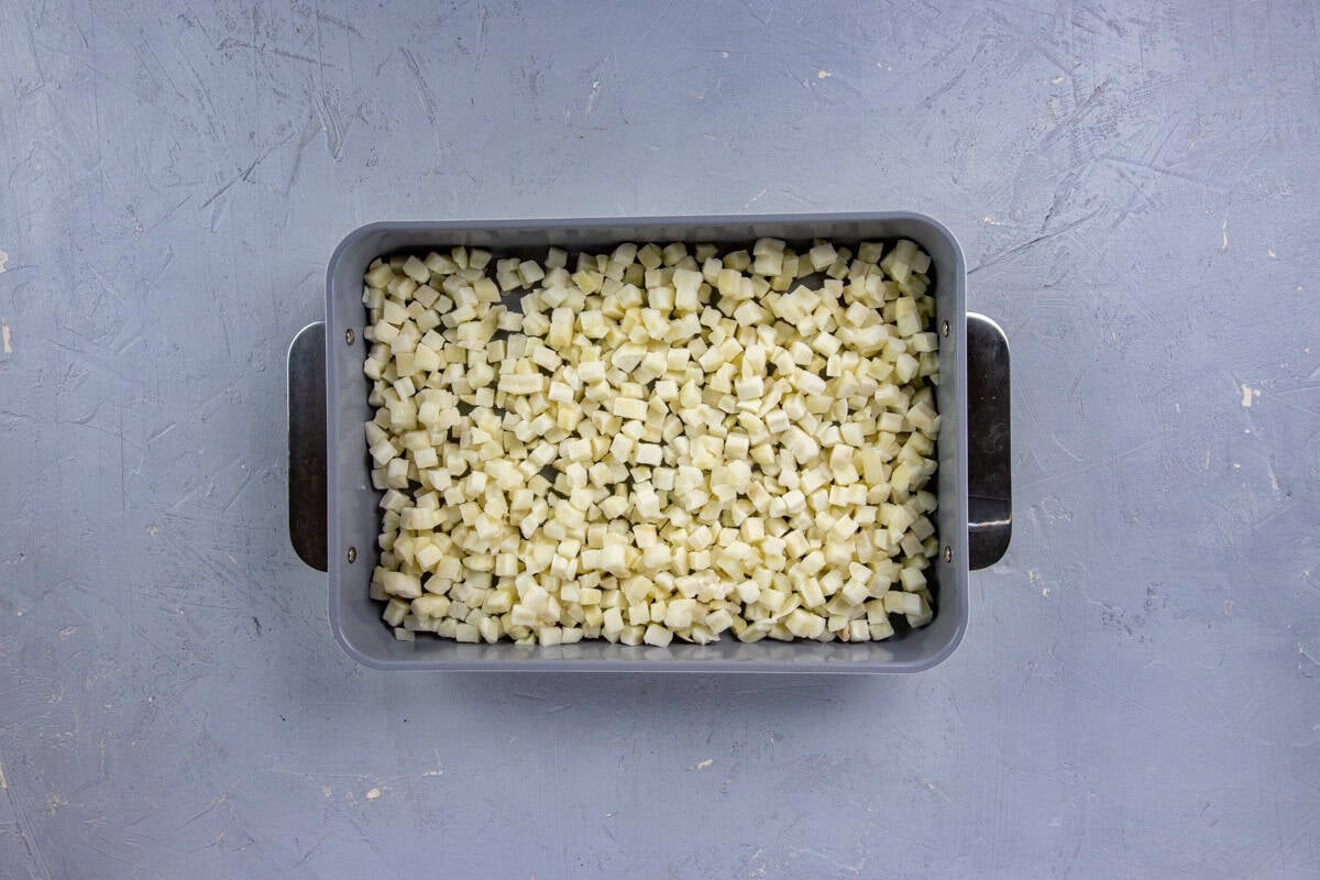 Thawed hashbrowns in a 9x13-inch casserole dish.