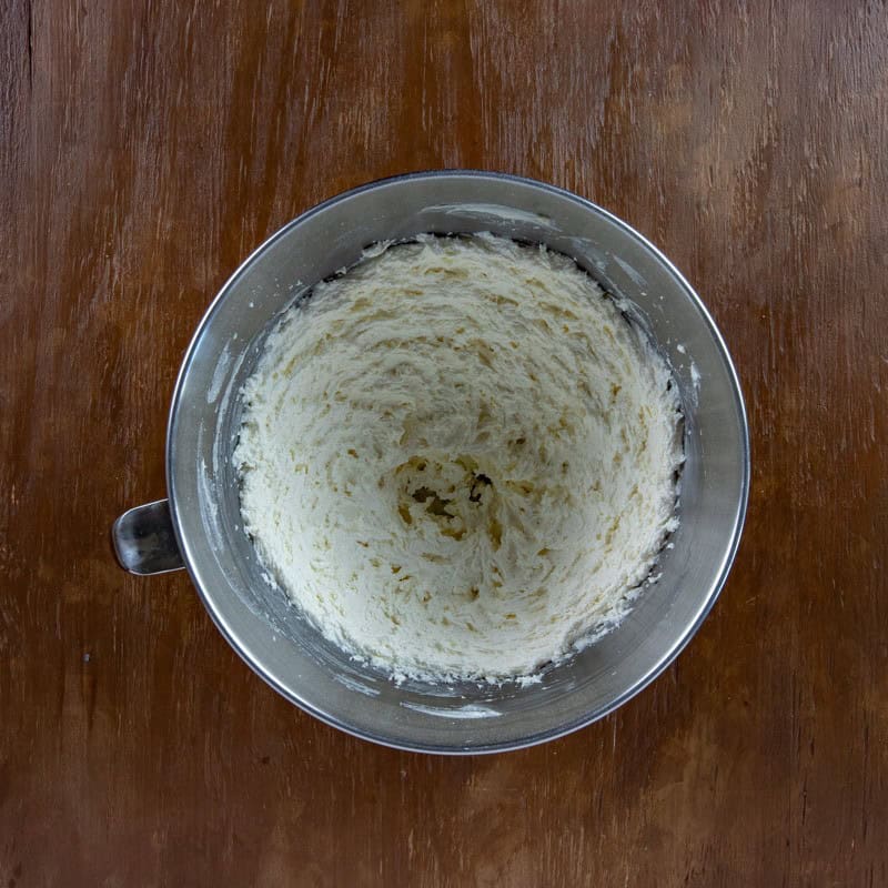 Butter and sugar blended in a mixing bowl.