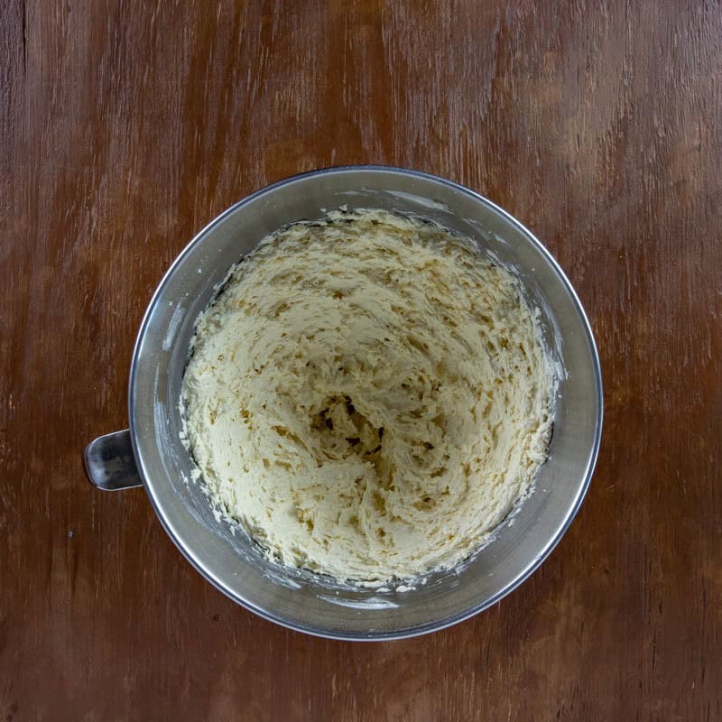 Egg and vanilla bean paste blended in with the butter and sugar in a mixing bowl.