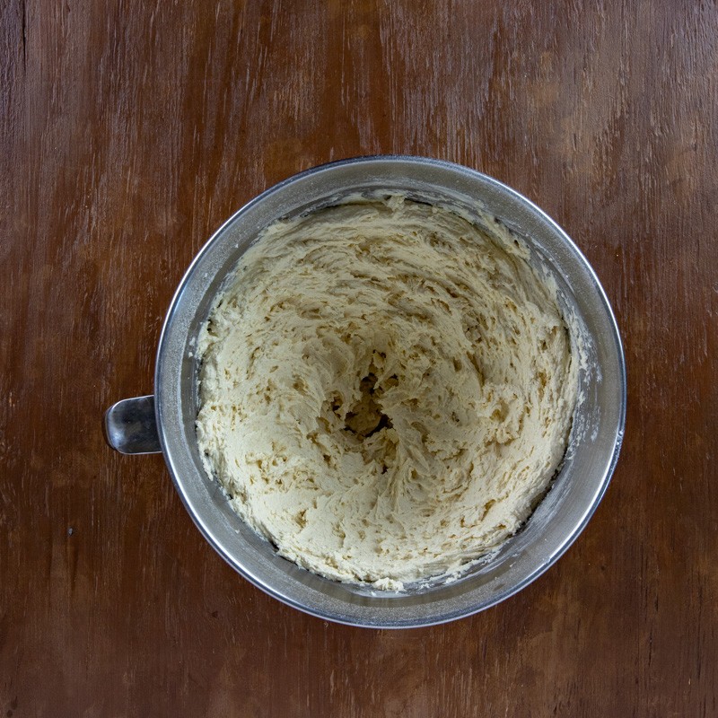Flour, baking soda, baking powder, and salt added to the egg and butter mixture in the mixing bowl.
