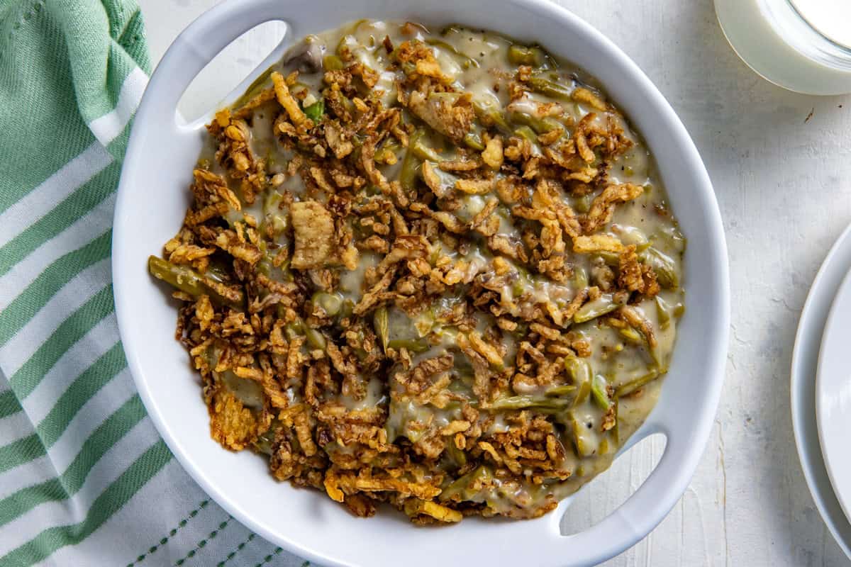 Cooked crockpot green bean casserole that's been transferred to a white serving bowl.