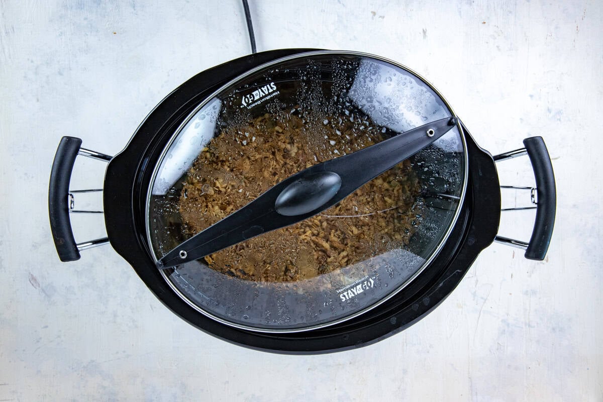 Green bean casserole cooking in the crockpot with the lid askew during the last 30 minutes so that the onions won't get soggy.