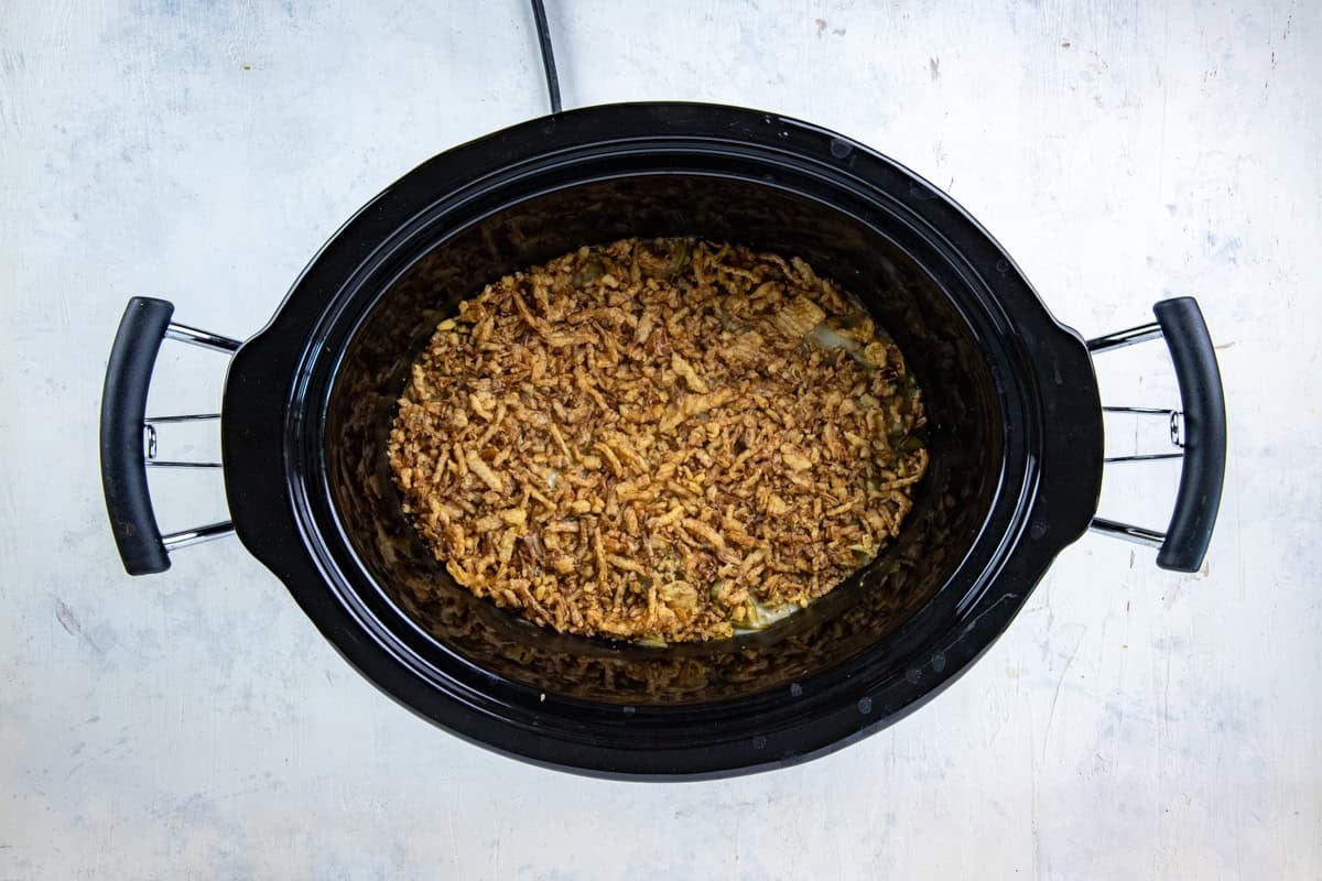 Cook green bean casserole in the slow cooker with a layer of crispy fried onions added on top.