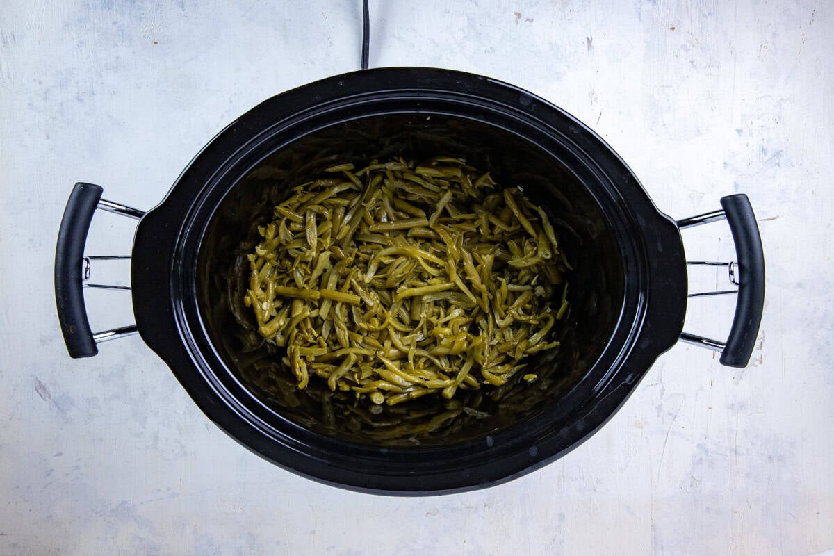 Drained canned beans added to the bottom of the slow cooker.