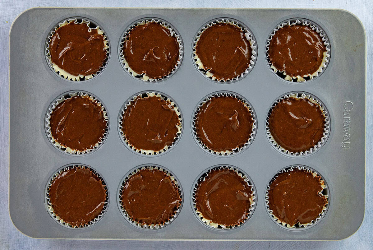 Nutella cheesecake layer on top of the vanilla cheesecake layer in the muffin pan.