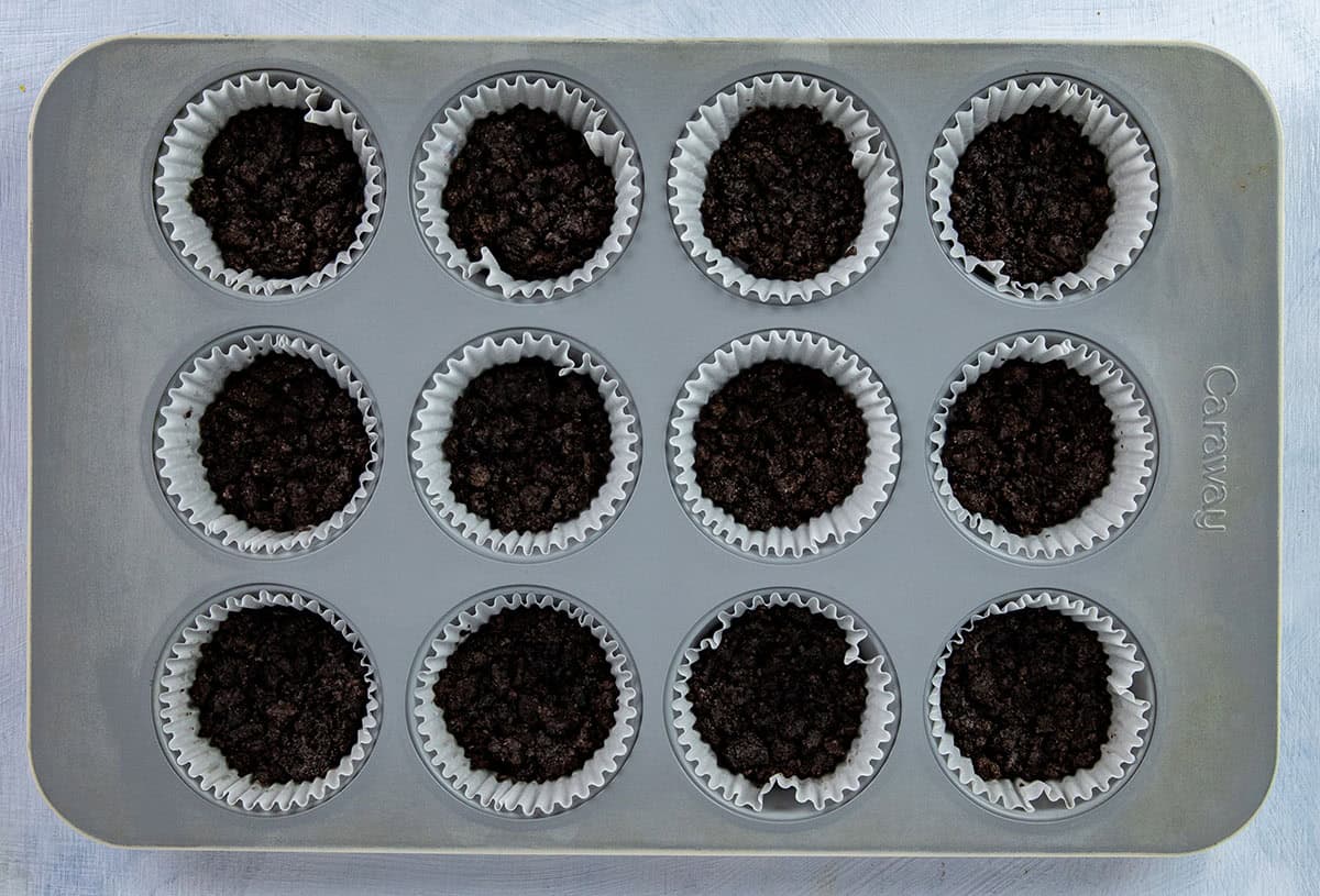 Crushed Oreo cookie crusts in 12-cup muffin pan,