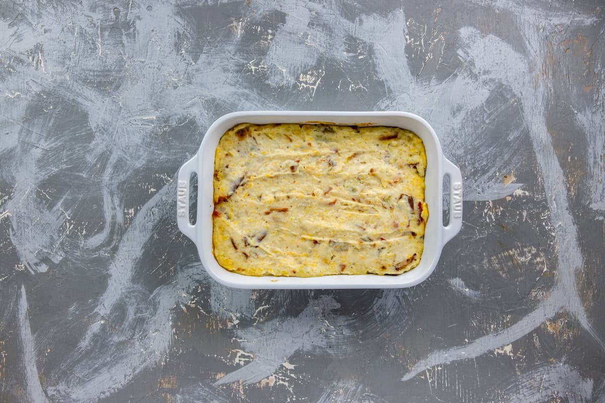 Unbaked potato mixture in a white casserole dish.