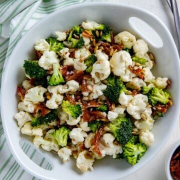 Broccoli and cauliflower salad in a white serving bowl.