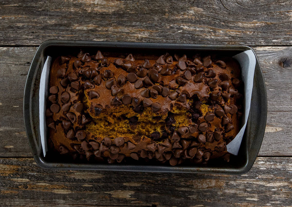 Overhead view of baked pumpkin bread topped with chocolate chips still in the loaf pan.