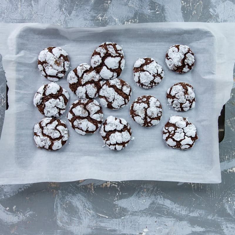 Baked cookies on parchment paper on a sheet pan.