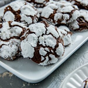 Baked cookies stacked on a white platter.