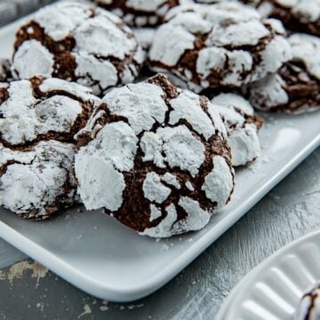 Baked cookies stacked on a white platter.