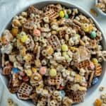 White chocolate chex mix in a white serving bowl.