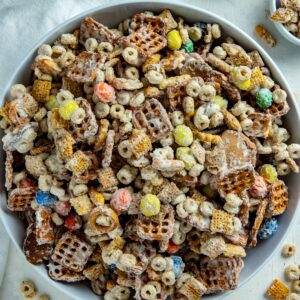 White chocolate chex mix in a white serving bowl.