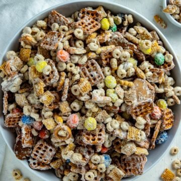 White chocolate chex mix in a white serving bowl.