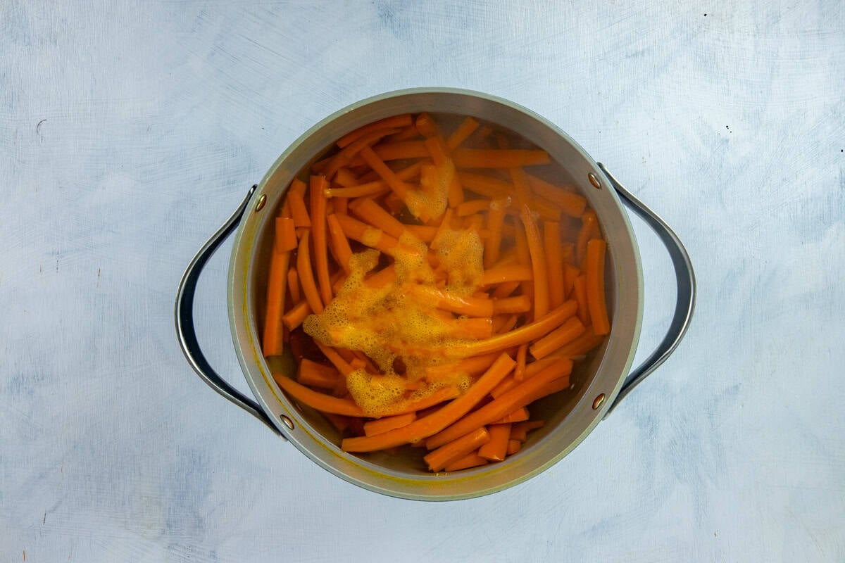 Sliced carrots boiled in a pot of water.