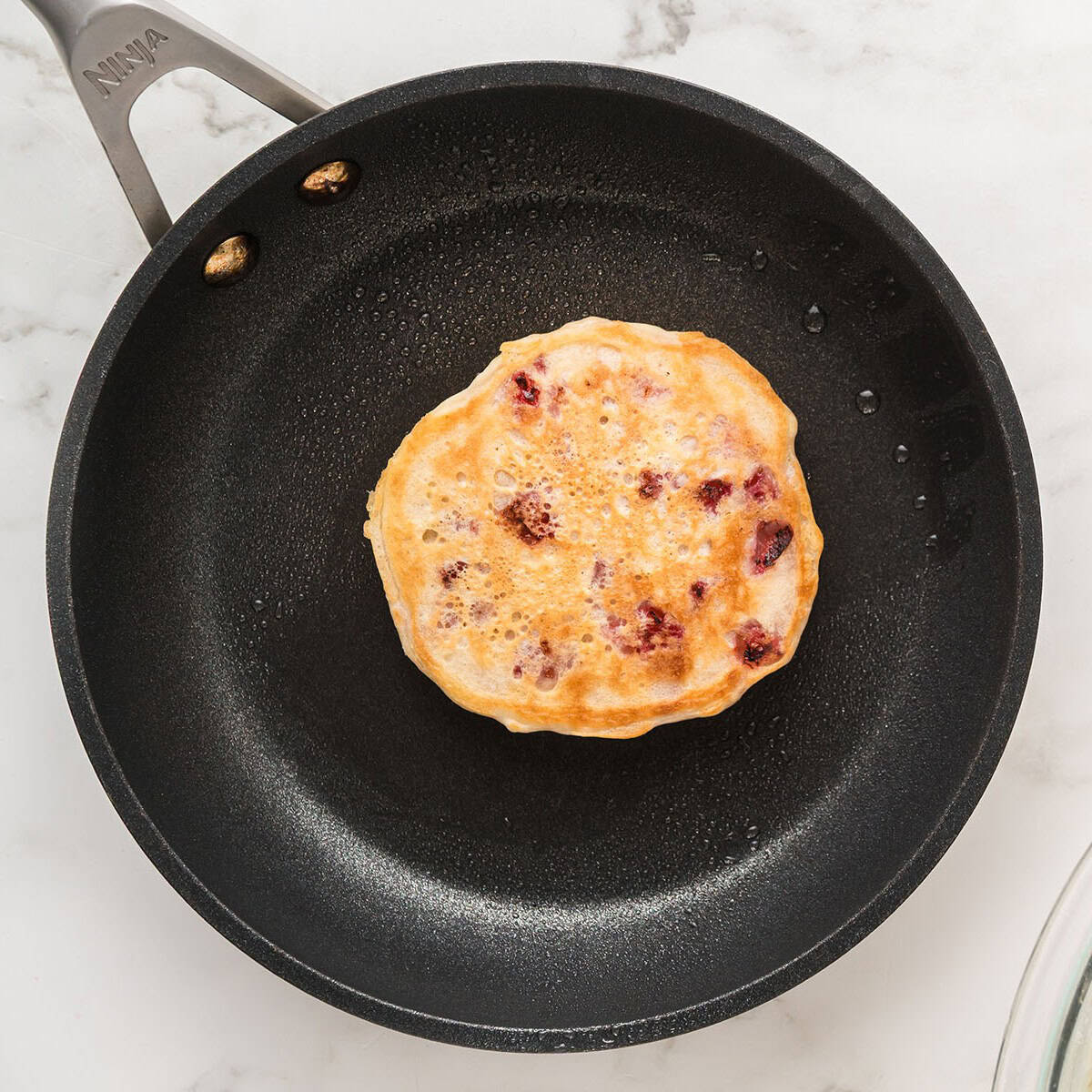 One cooked pancake still in the skillet.