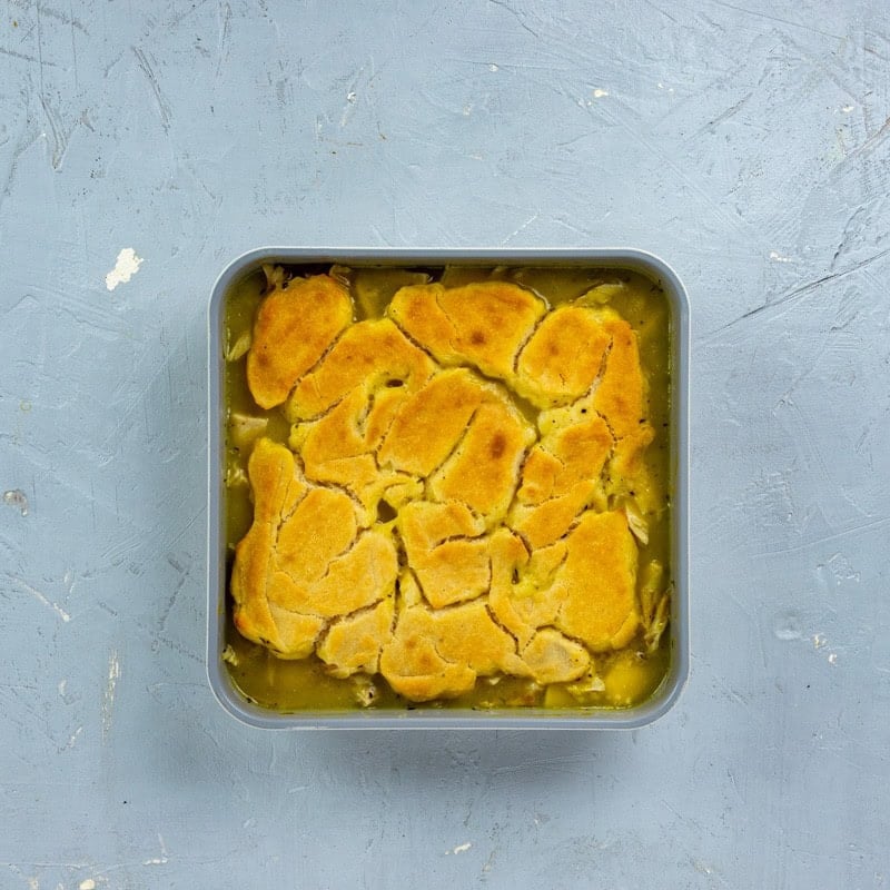 Baked chicken cobbler in a square dish.