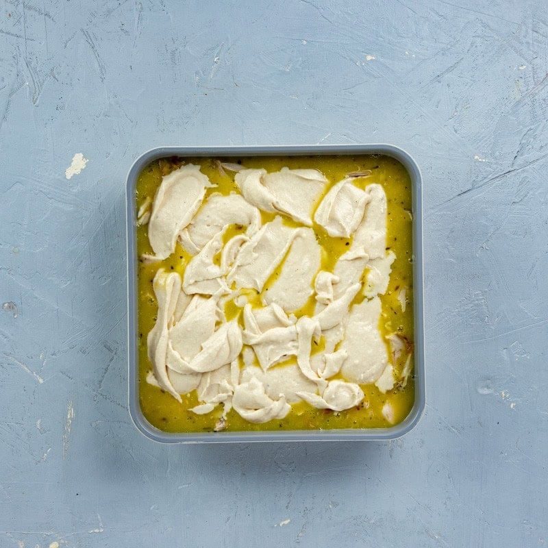 Flour, milk, and butter mixture spread over the top of the chicken.