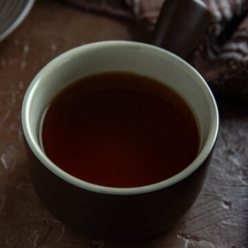 Beef broth in a small round bowl.