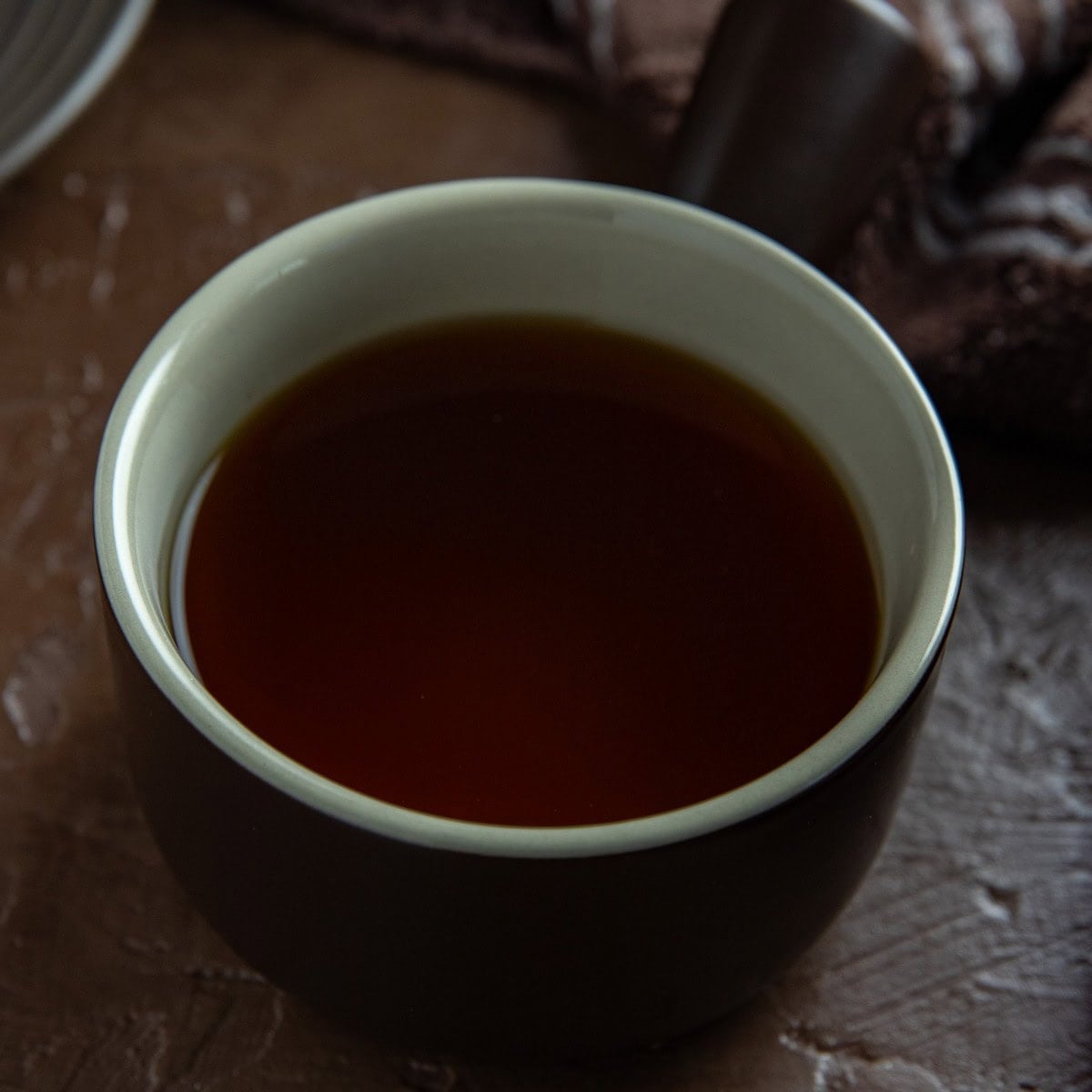 Beef broth in a small round bowl.