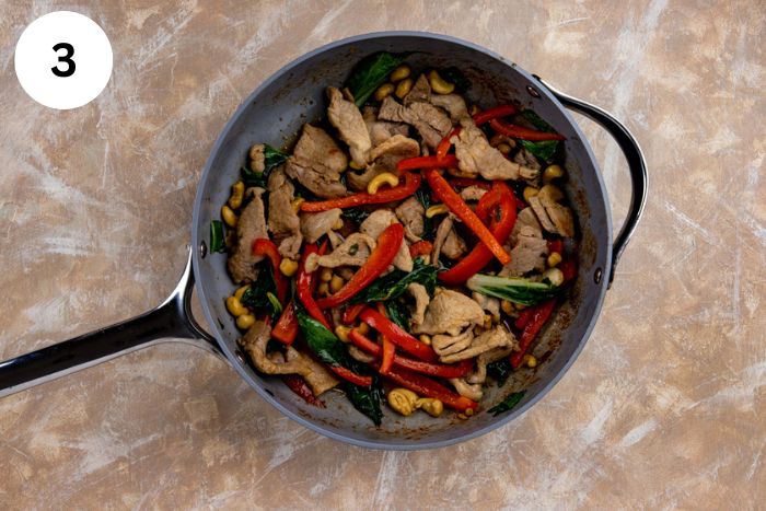 Bok choy, sesame oil, and tamari added to the skillet with the pork and vegetables.