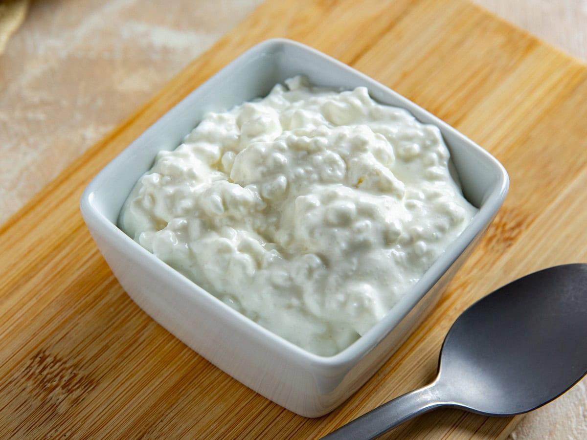 Cottage cheese in a small, white, square bowl.
