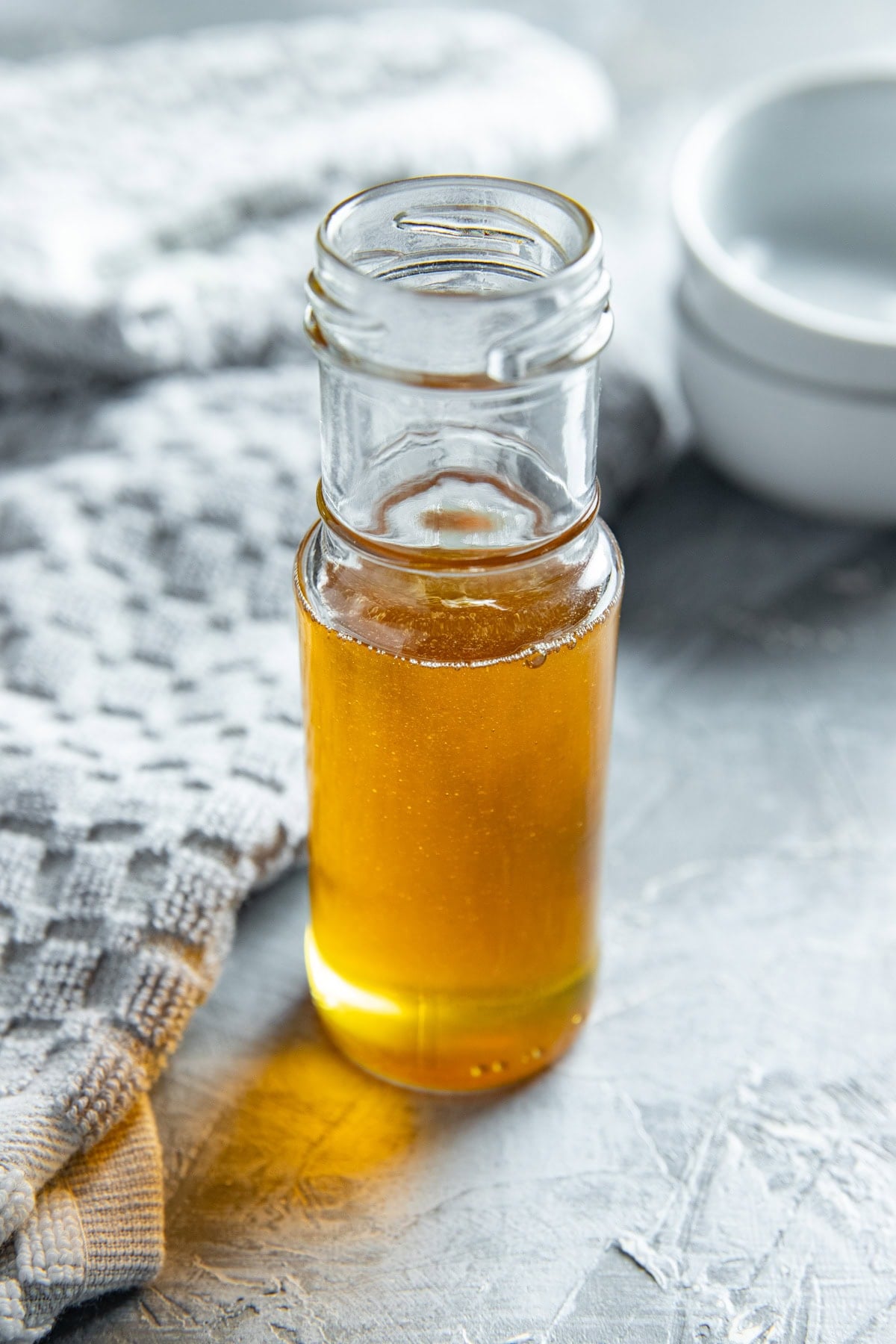 Honey in a tall slender glass container.