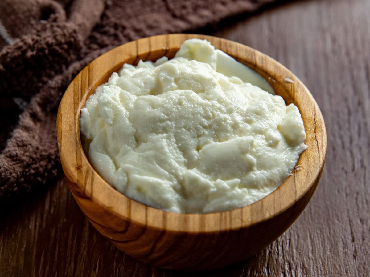 Ricotta cheese in a small wooden bowl.