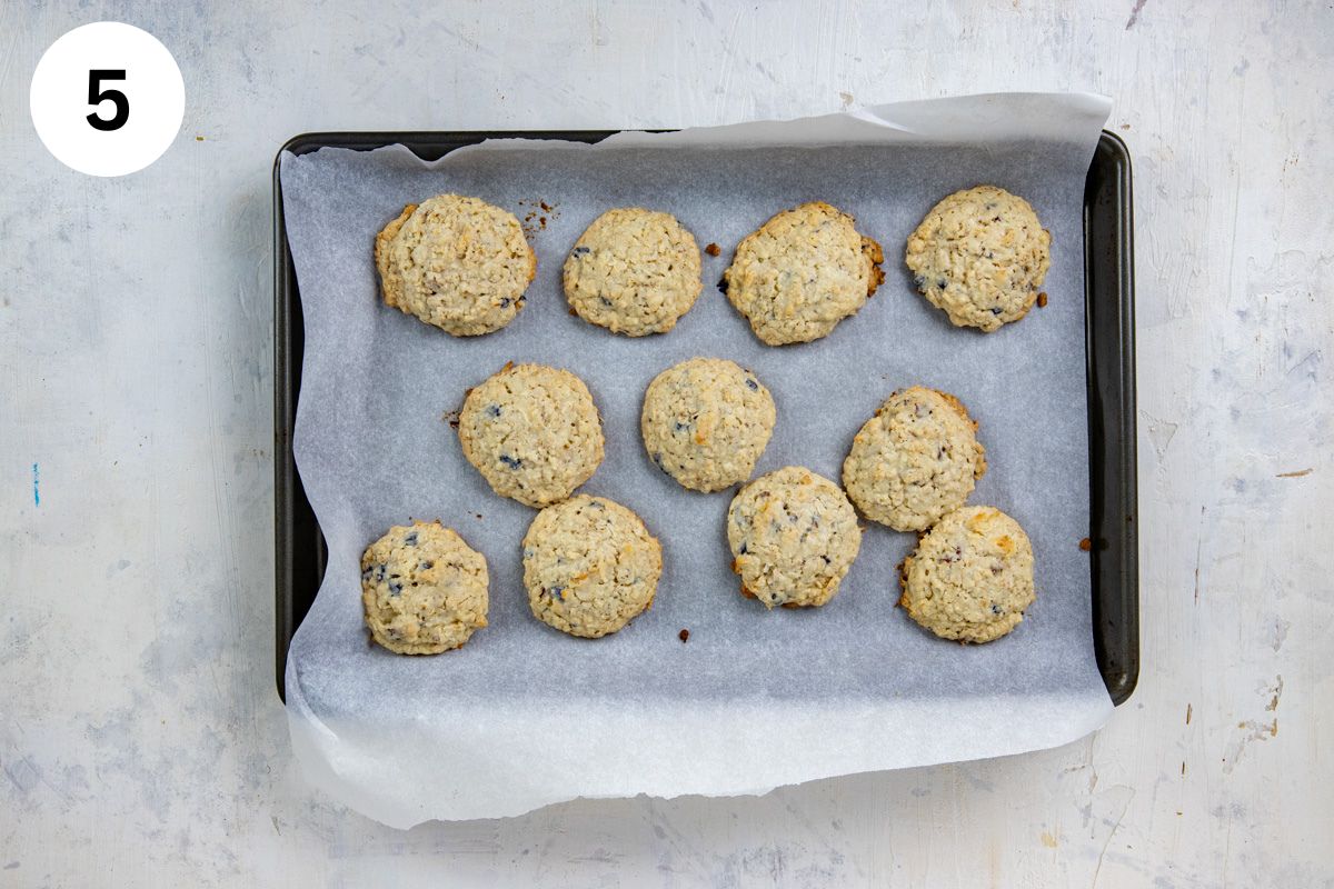Eleven baked cookies on parchment paper on cookie sheet.