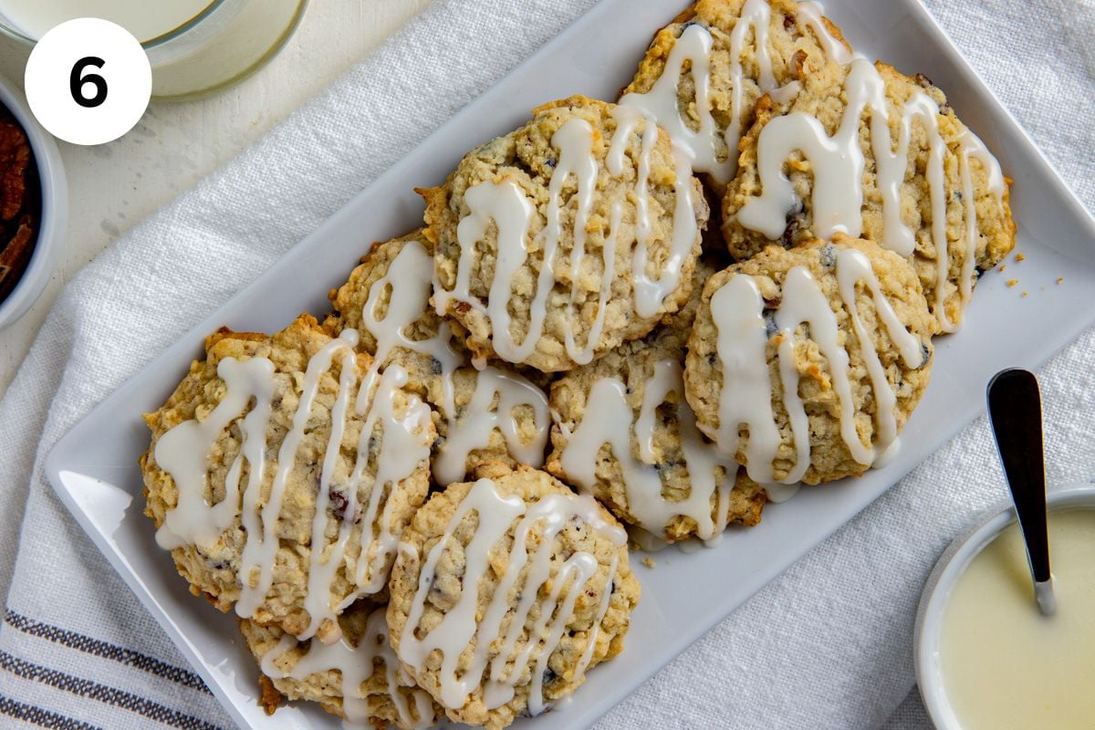 Baked and frosted cookies piled on a white serving platter.