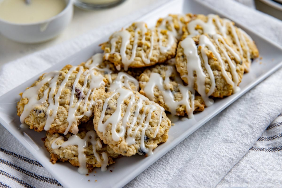Baked and frosted cookies piled on a white serving platter.