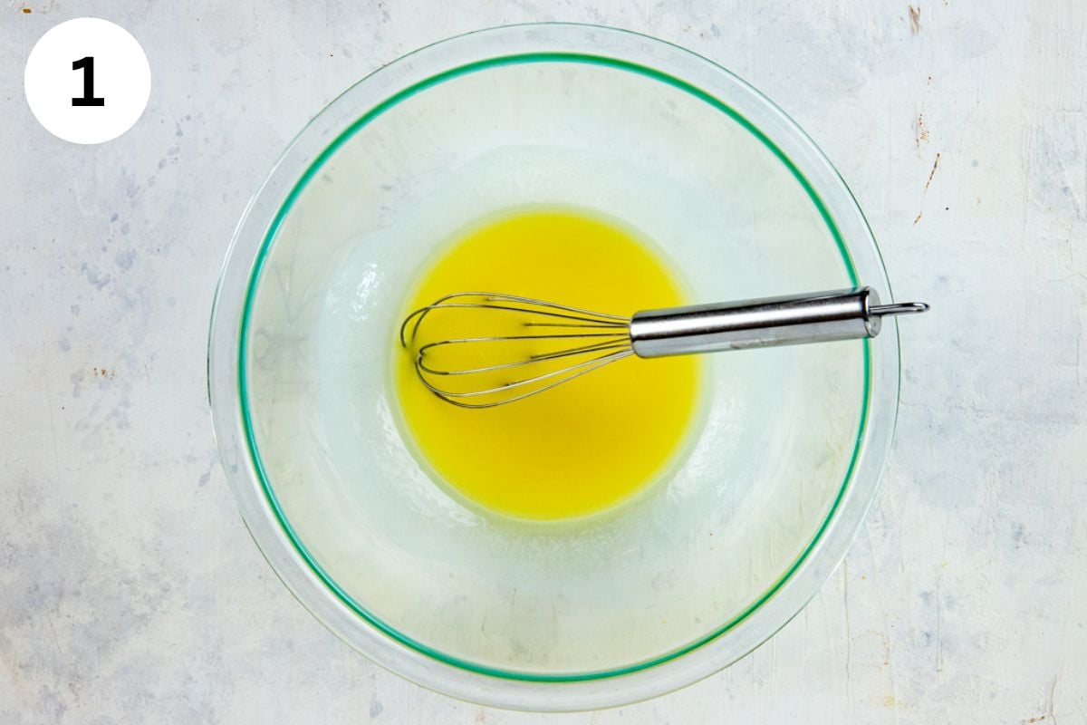 Softened butter in glass bowl with a whisk.