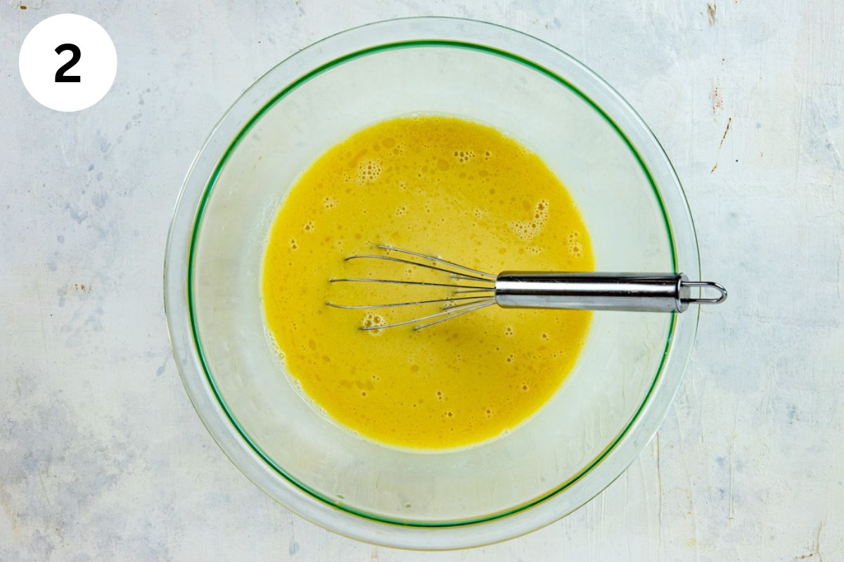 Milk, eggs, and vanilla extract added to the butter in the same glass bowl.