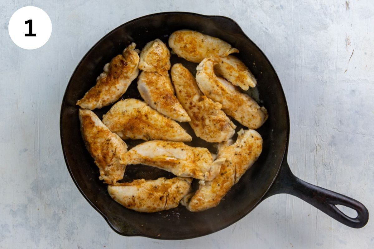 Seasoned and cooked chicken tenderloins in a cast iron skillet.