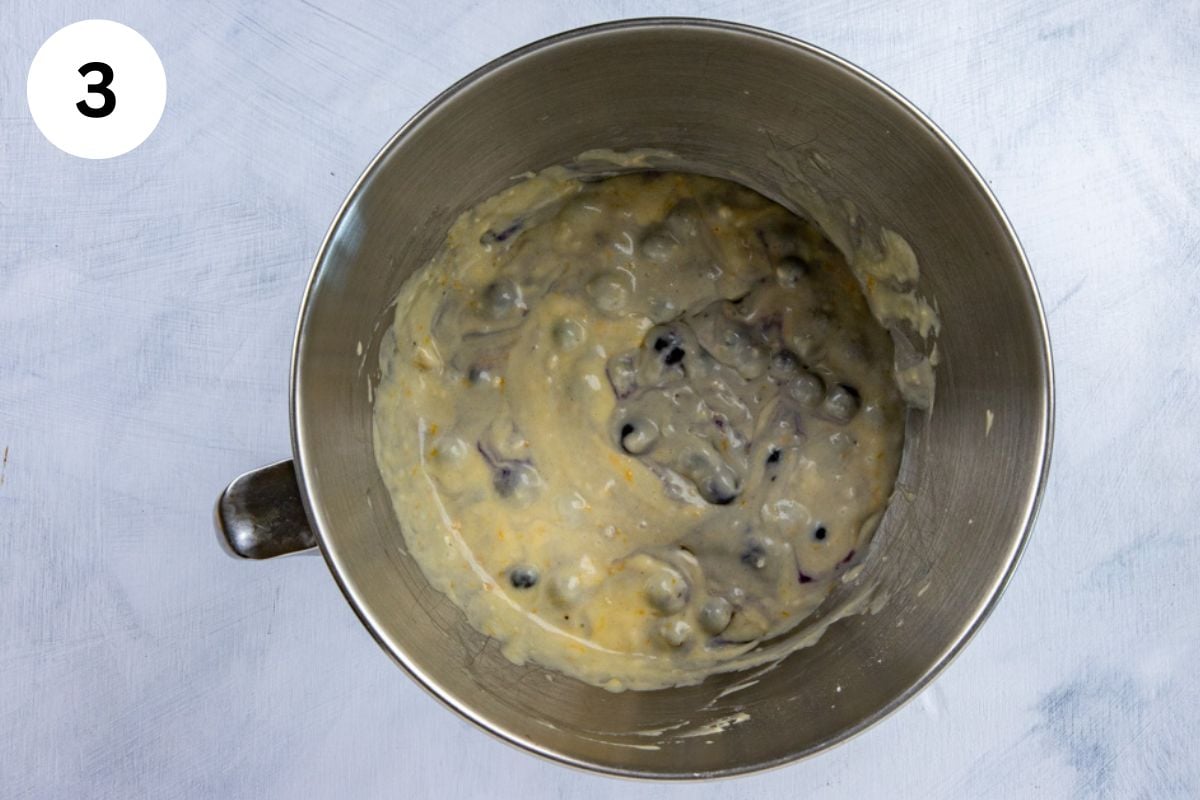 Blueberries folded into the batter in the bowl.