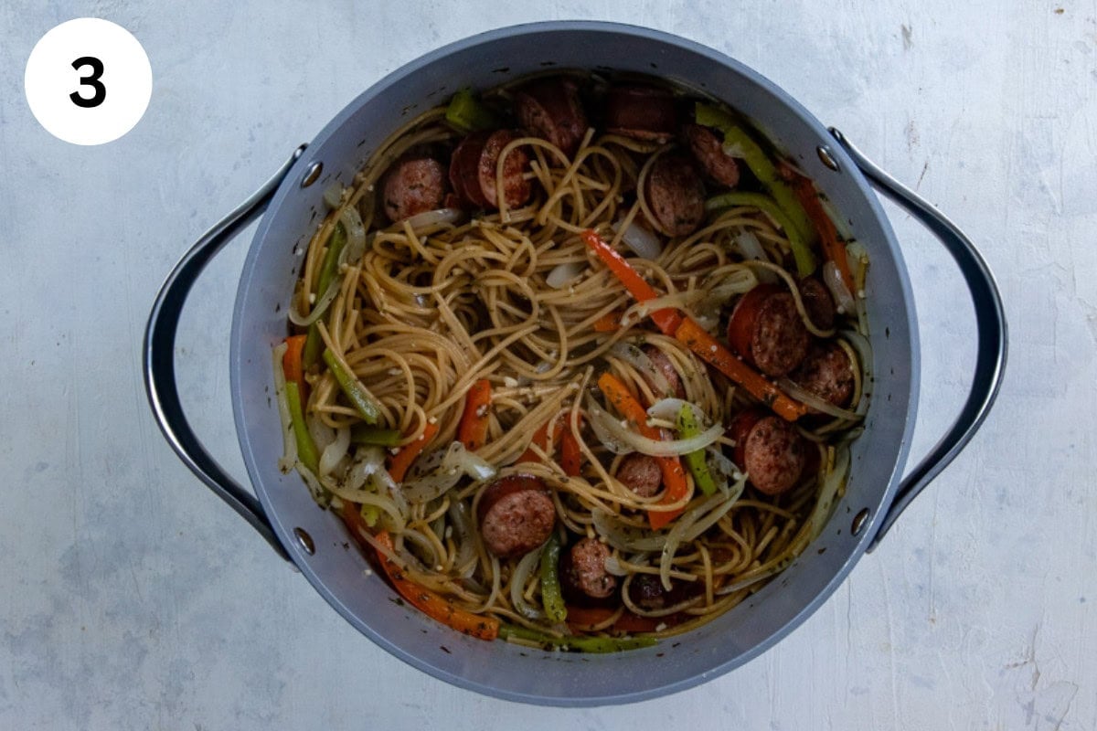 Sausage, onions, bell peppers, broth, seasonings, and spaghetti in the pot.