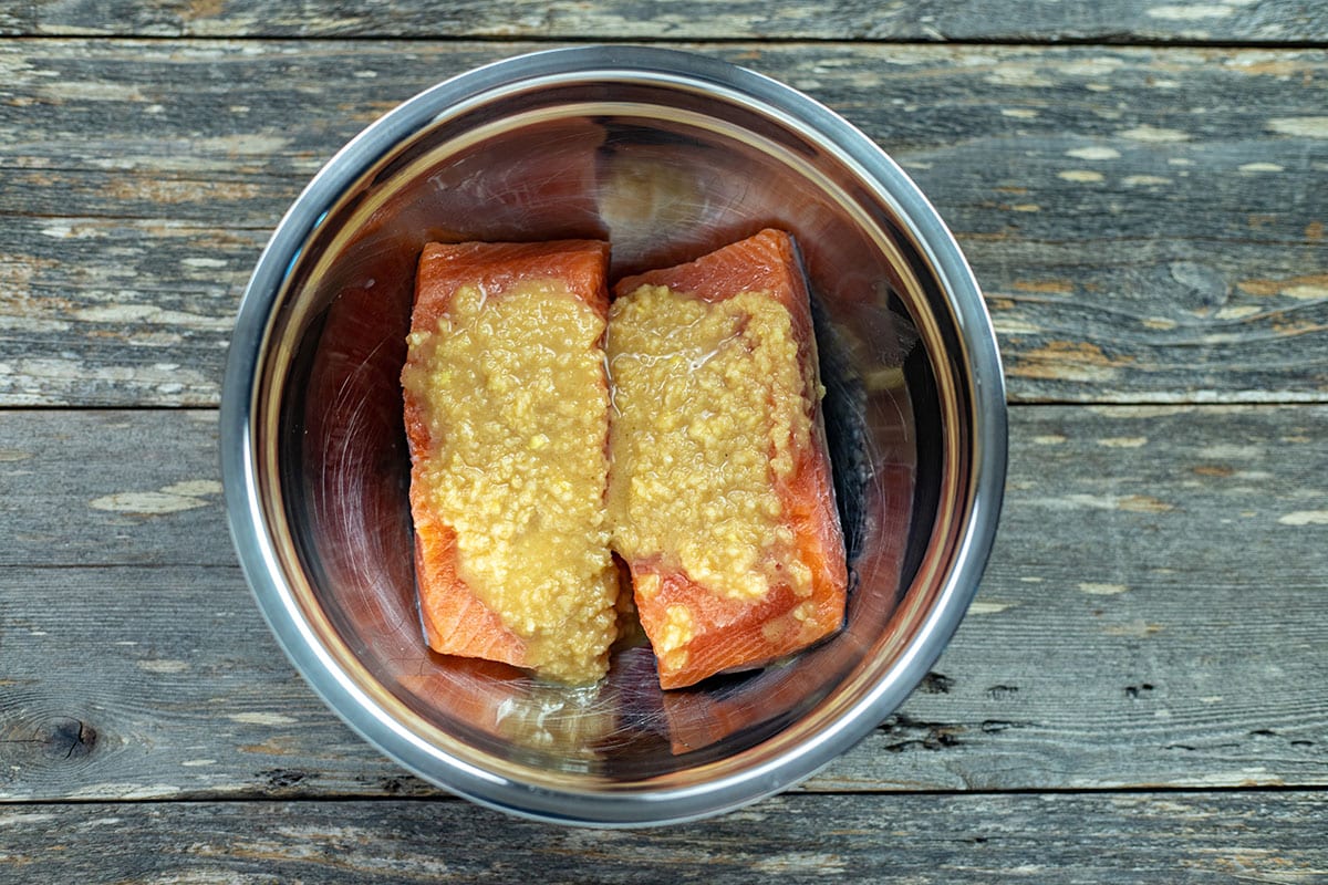Half the miso marinade on top of the uncooked salmon fillets.