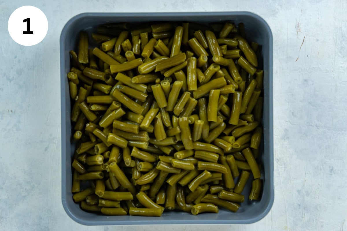 Layer of green beans in bottom of a square casserole dish.