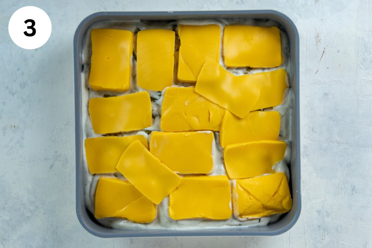 A layer of sliced Velveeta cheese on top of the creamy soup mixture.