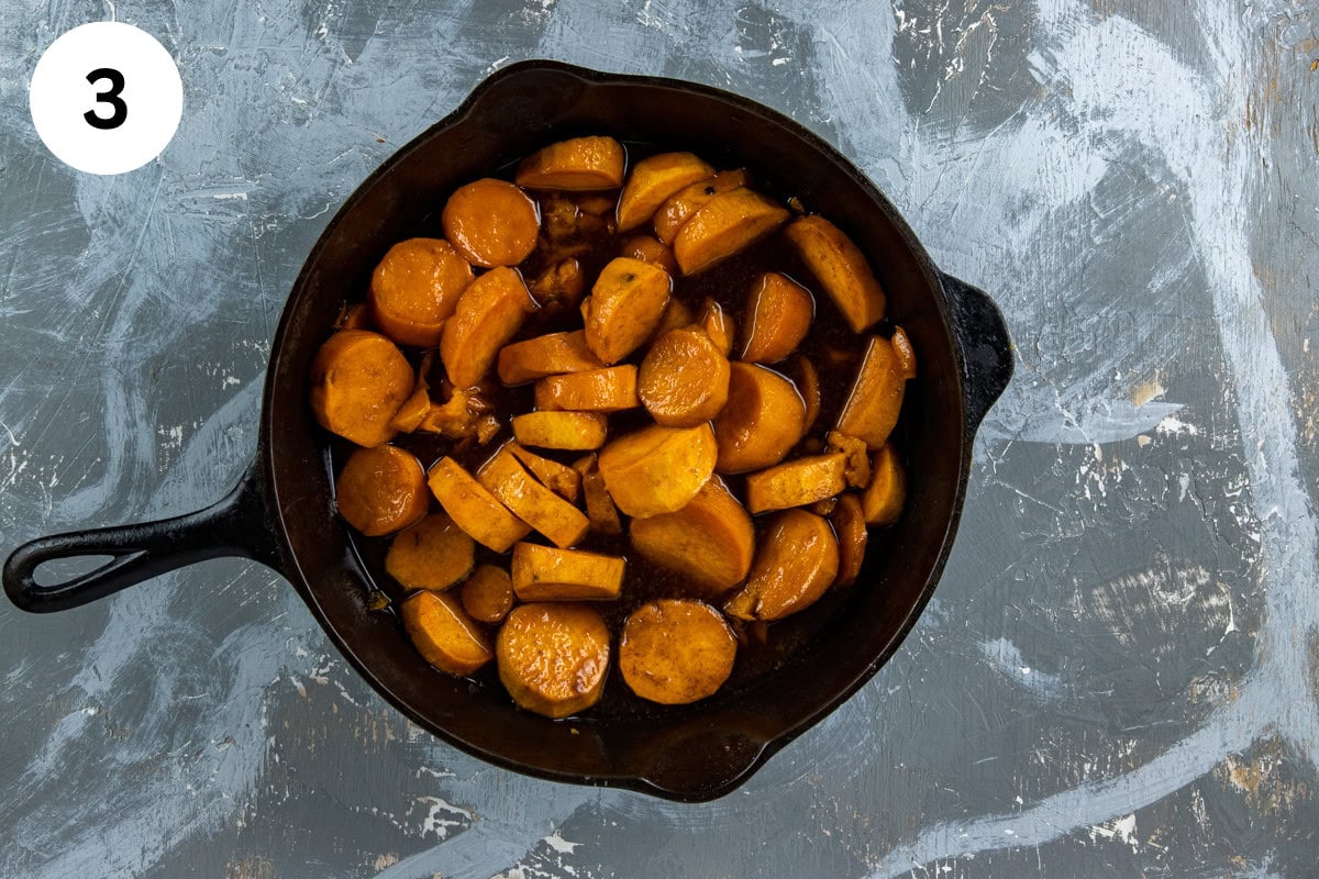 Cooked sweet potatoes in cast iron skillet with maple extract stirred in.