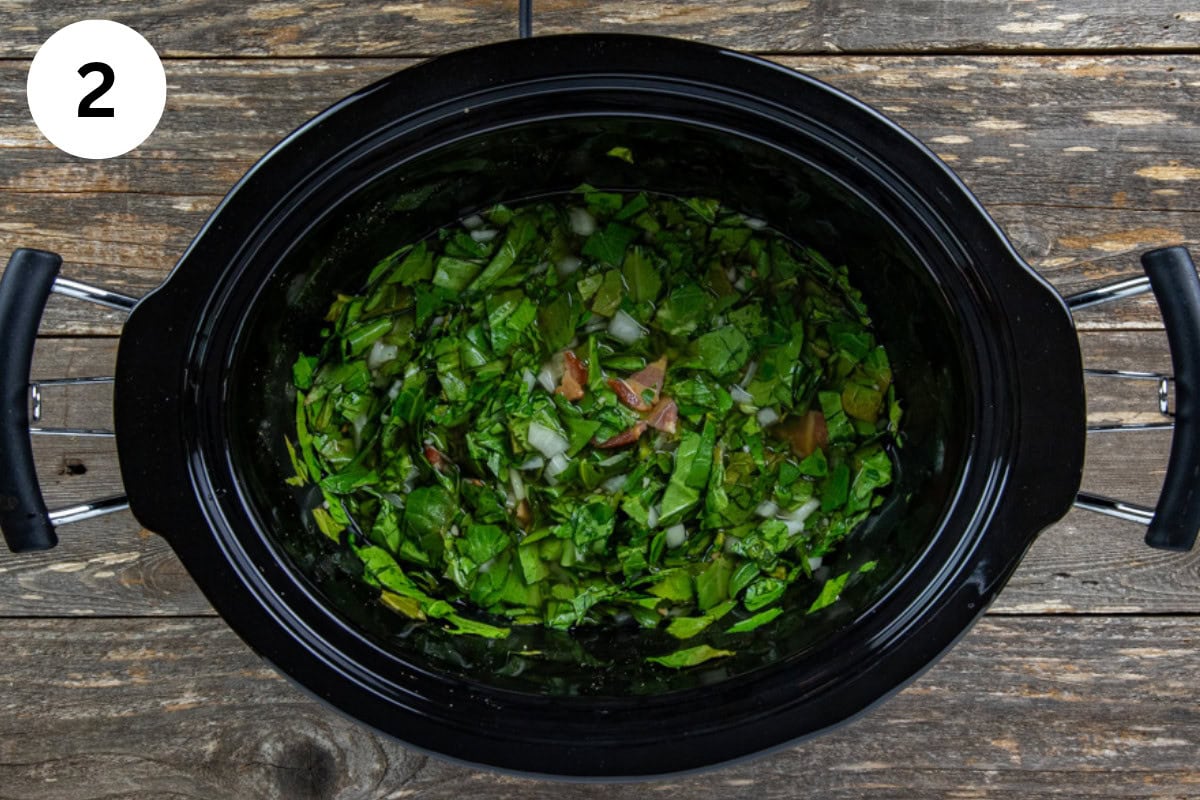 Bacon, onion, garlic, salt, sugar, collard greens, apple cider vinegar, and chicken broth layered in a crockpot.