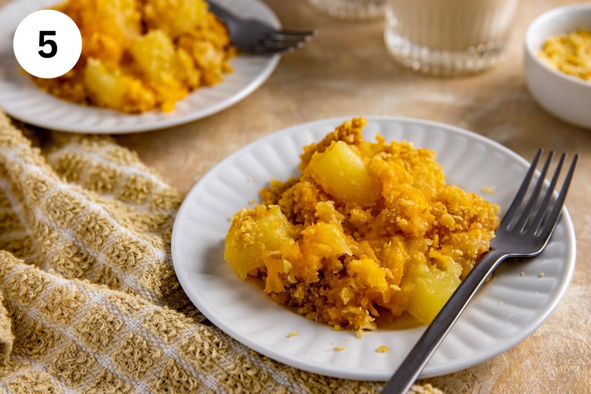 A serving of baked pineapple casserole on a white plate with fork.
