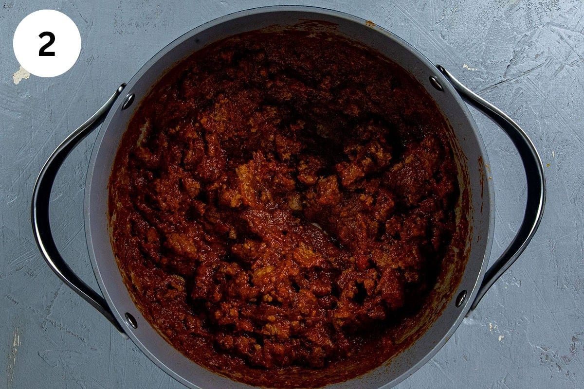 Marinara sauce, tomato paste, and seasonings added to the pot with the ground beef.